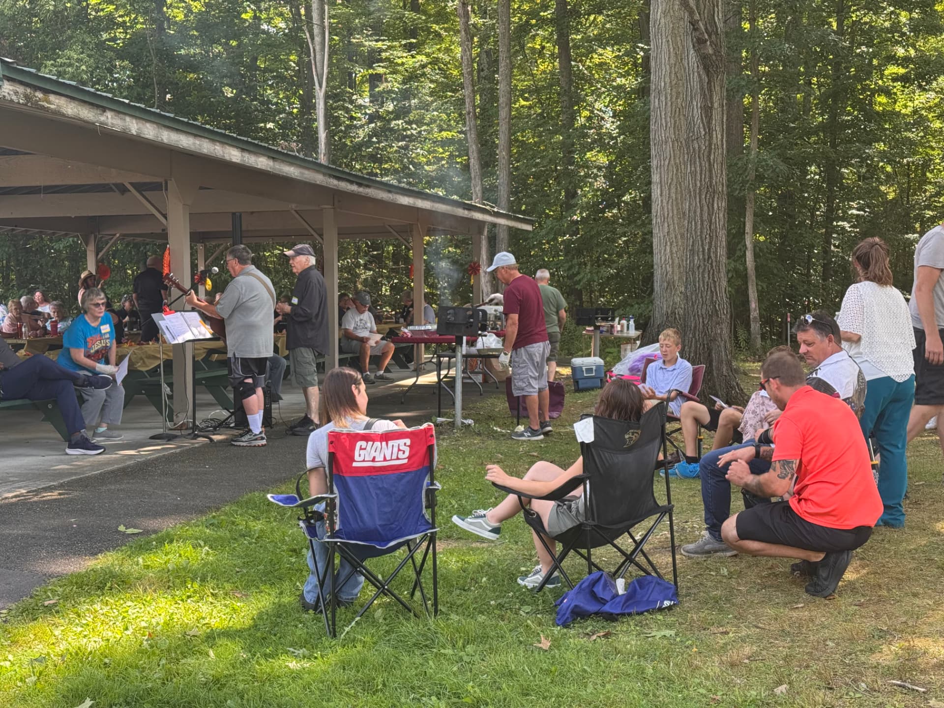 Families enjoying live music and grilling outside the pavilion
