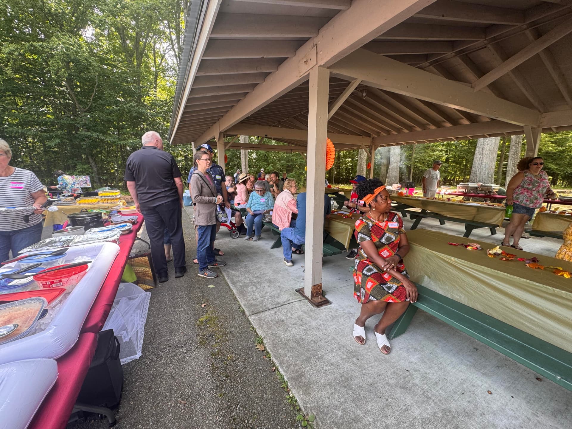 Church family gathering under the pavilion with tables of picnic food