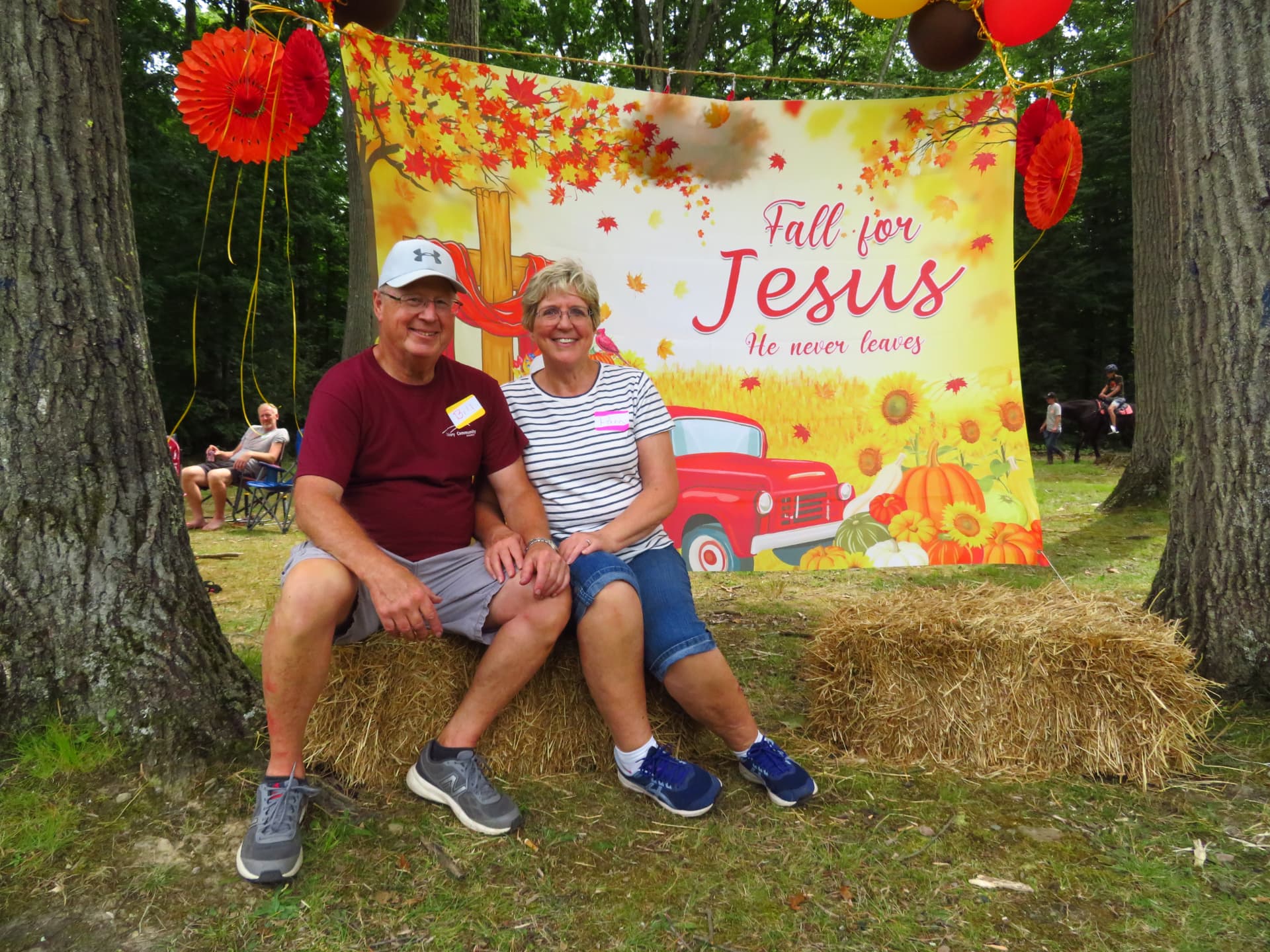 A couple seated together in front of the Fall for Jesus banner