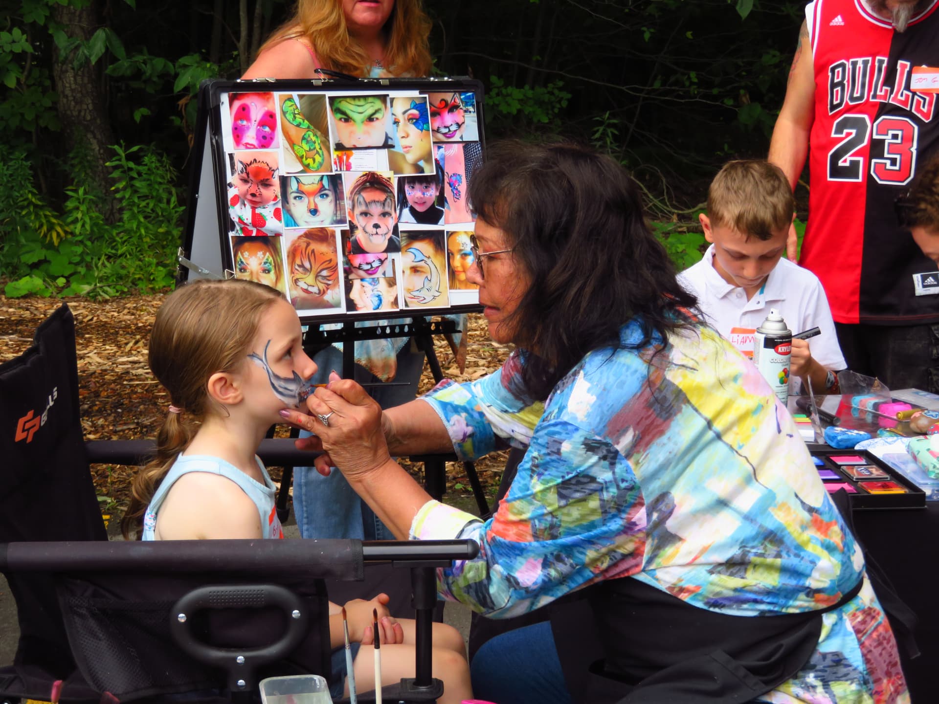 Linda Conroy face painting a young girl at the picnic